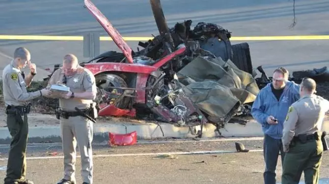 Oibríonn teachtaí an tsirriam gar do raic carr spóirt Porsche a thit isteach i cuaille solais ar Shráid Hercules in aice le Kelly Johnson Parkway i Valencia Dé Sathairn, 30 Samhain, 2013. Deir poiblitheoir don aisteoir Paul Walker go bhfuil réalta an